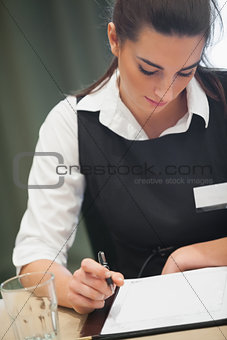 Businesswoman looking down at notepad