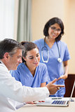 Doctor showing nurses something on laptop