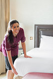Hotel maid making bed