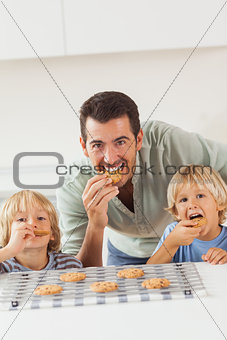 Father and his sons eating cookies