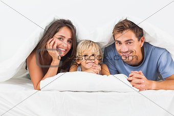 Family smiling under the duvet