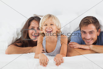 Happy family lying on a bed together