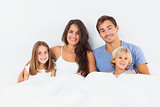 Cheerful family lying on a bed together