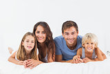 Smiling family lying on a bed