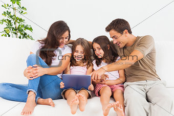 Smiling family using a digital tablet