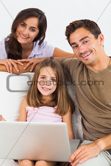 Smiling family using the laptop