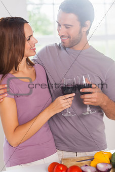 Lovers toasting standing with a glass of wine