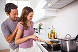 Woman making dinner with partner watching