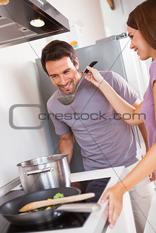 Woman getting man to taste dinner
