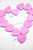 Pink confetti hearts making heart shape over valentines day