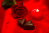 Red rose candle and chocolate hearts