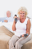 Elderly woman lifting dumbbells