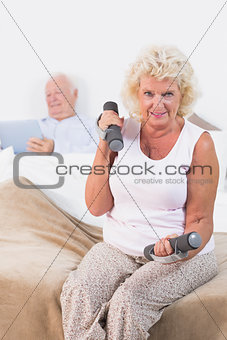 Elderly woman lifting dumbbells