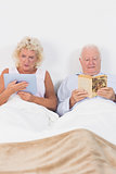 Old couple reading or using a digital tablet