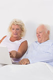 Focused aged couple using a laptop