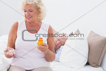 Aged woman with the opened pill bottle