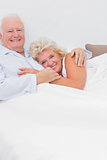 Smiling couple lying on the bed