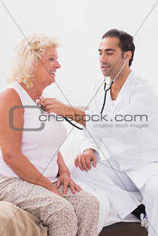 Doctor examining a smiling old woman