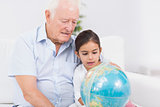 Granddaughter and grandfather with globe