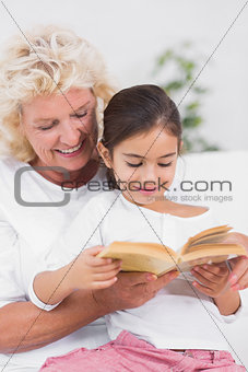 Granddaughter and grandmother reading a novel together