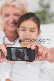 Cheerful granddaughter and grandmother taking photos