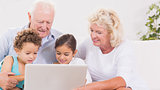 Grandparents with children using a laptop