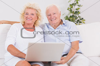 Old couple using a laptop together