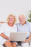Aged couple using a laptop together