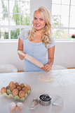 Smiling woman with a rolling pin and ingredients
