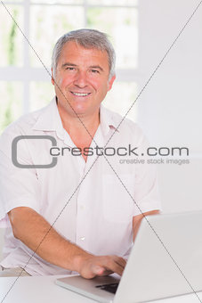 Old man using a white laptop