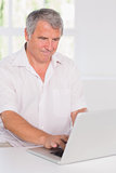 Old man concentrating in front of his laptop