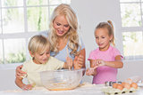 Children mixing dough with their mother