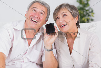 Old couple listening to a smartphone
