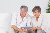 Old couple watching tablet pc