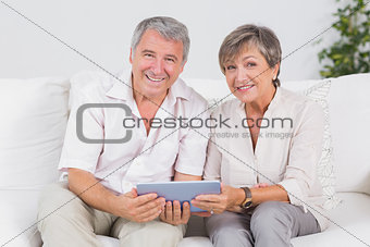 Old couple looking camera with tablet pc