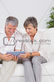 Old couple looking tablet pc with smiling