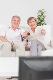 Old couple watching TV and pointing