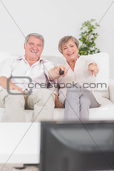 Old couple watching TV and pointing