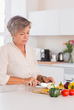 Old woman cutting vegetables on a cutting board