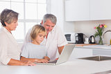 Child and grandparents looking at laptop