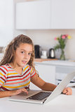 Child looking at the camera with laptop