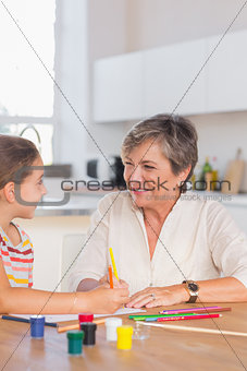 Smiling child with her granny drawing