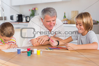 Grandfather and her grandchildren drawing