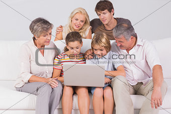 Family looking at laptop on couch