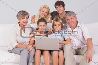 Family portrait looking at camera with a laptop