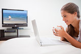 Woman surfing the internet while having a cup of coffee