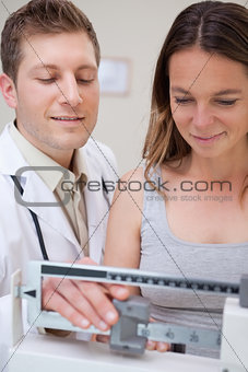 Doctor and patient adjusting scale