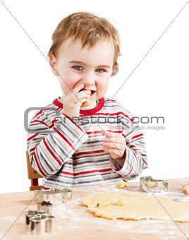 happy young child nibbling dough in white background