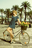 blonde woman in sexy pose near bicycle 