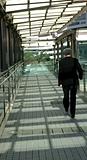 Businessman walking on modern bridge